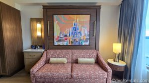 A Mary Blair-inspired piece of art featuring Mickey and Minnie and Cinderella Castle at Magic Kingdom is seen over the sofa in a Villa at Bay Lake Tower.