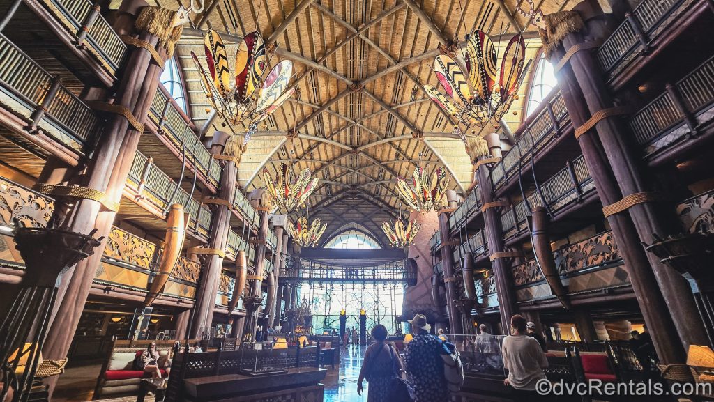 Guests explore the African-inspired décor and artifacts in the lobby of Disney’s Animal Kingdom Villas Jambo House.