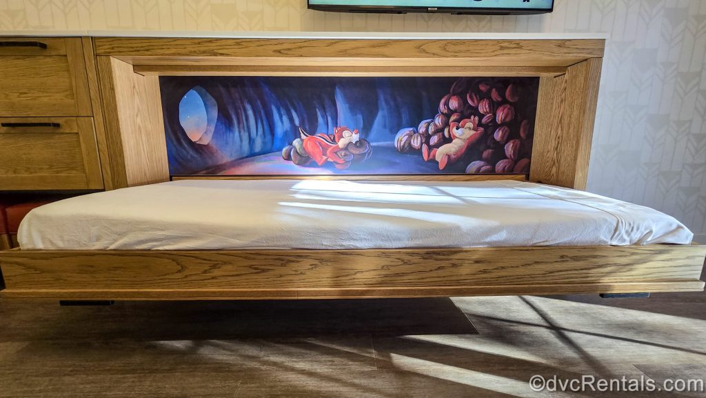 A mural of Chip ‘n Dale having a nap with their stash of acorns is seen behind the pull-down bunk-style bed in a Deluxe Studio at the Boulder Ridge Villas at Disney’s Wilderness Lodge.