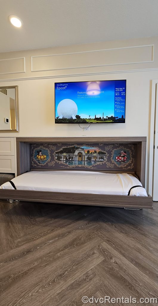 The pull-down bunk-style bed is pulled down in a Studio at Disney’s BoardWalk Villas, revealing the Mickey and Minnie-themed artwork and mattress.