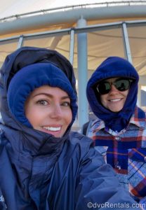 David’s Vacation Club Rentals team members Stacy R. and Olivia smile for the camera in their coats and jackets as they enjoy glacier viewing on the Disney Magic.