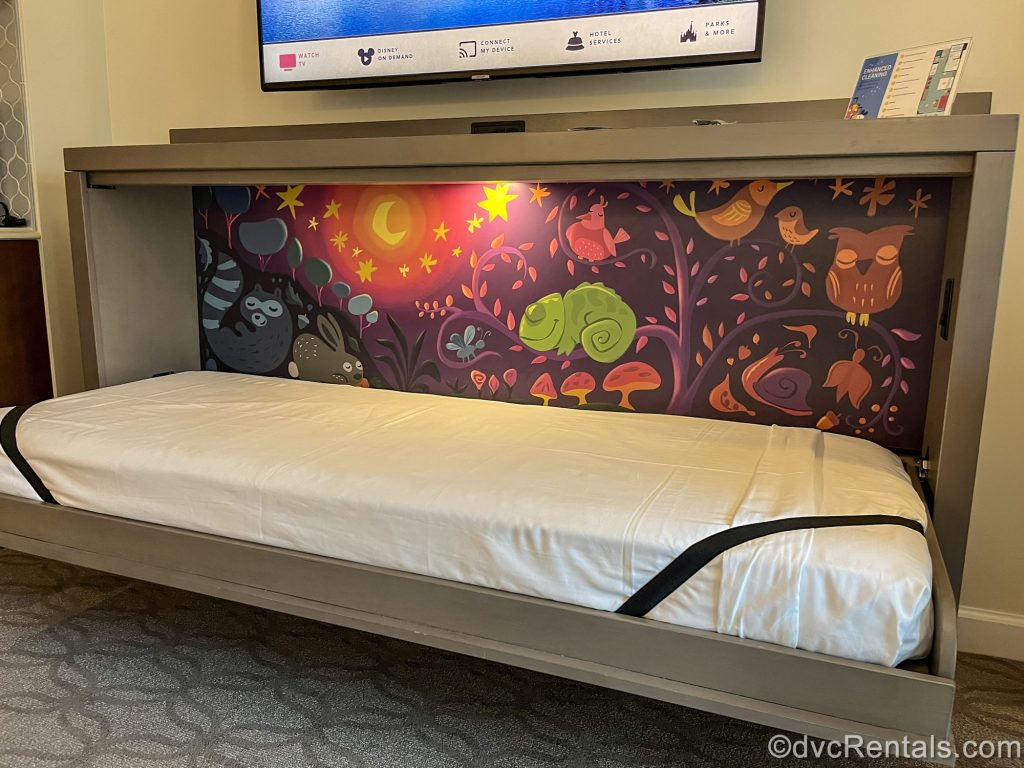 Pascal, the chameleon sidekick from the movie Tangled is seen in a mural with other woodland creatures behind the pull-down bunk-style bed in the Deluxe Studio at Disney’s Riviera Resort.