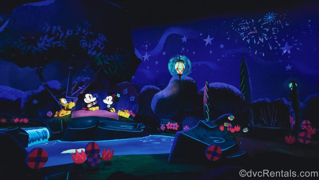 Mickey, Minnie, and Pluto enjoy an evening picnic under fireworks at the end as part of the Hollywood Studios attraction at Walt Disney World.